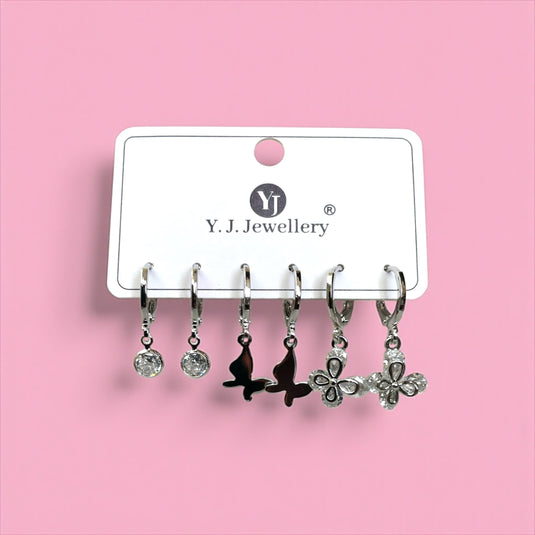 Set of earrings on a Y.J. Jewellery card against a pink background