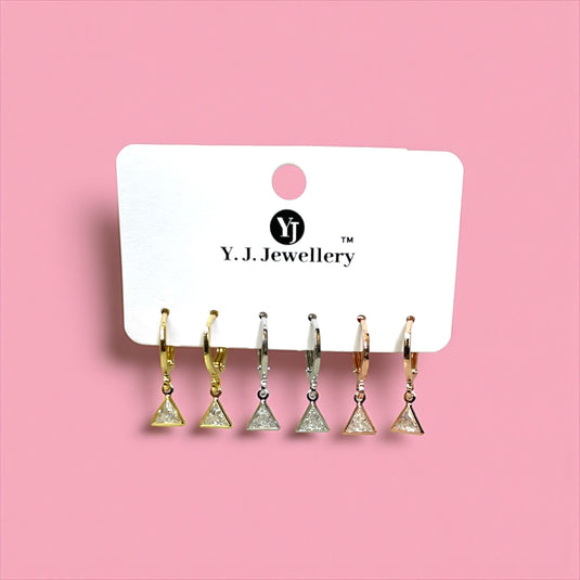 Set of triangle-shaped earrings on a Y.J. Jewellery card against a pink background